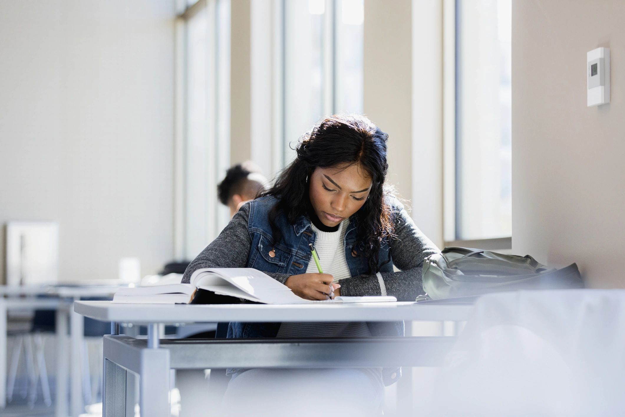 Student studying with a notebook at a desk.